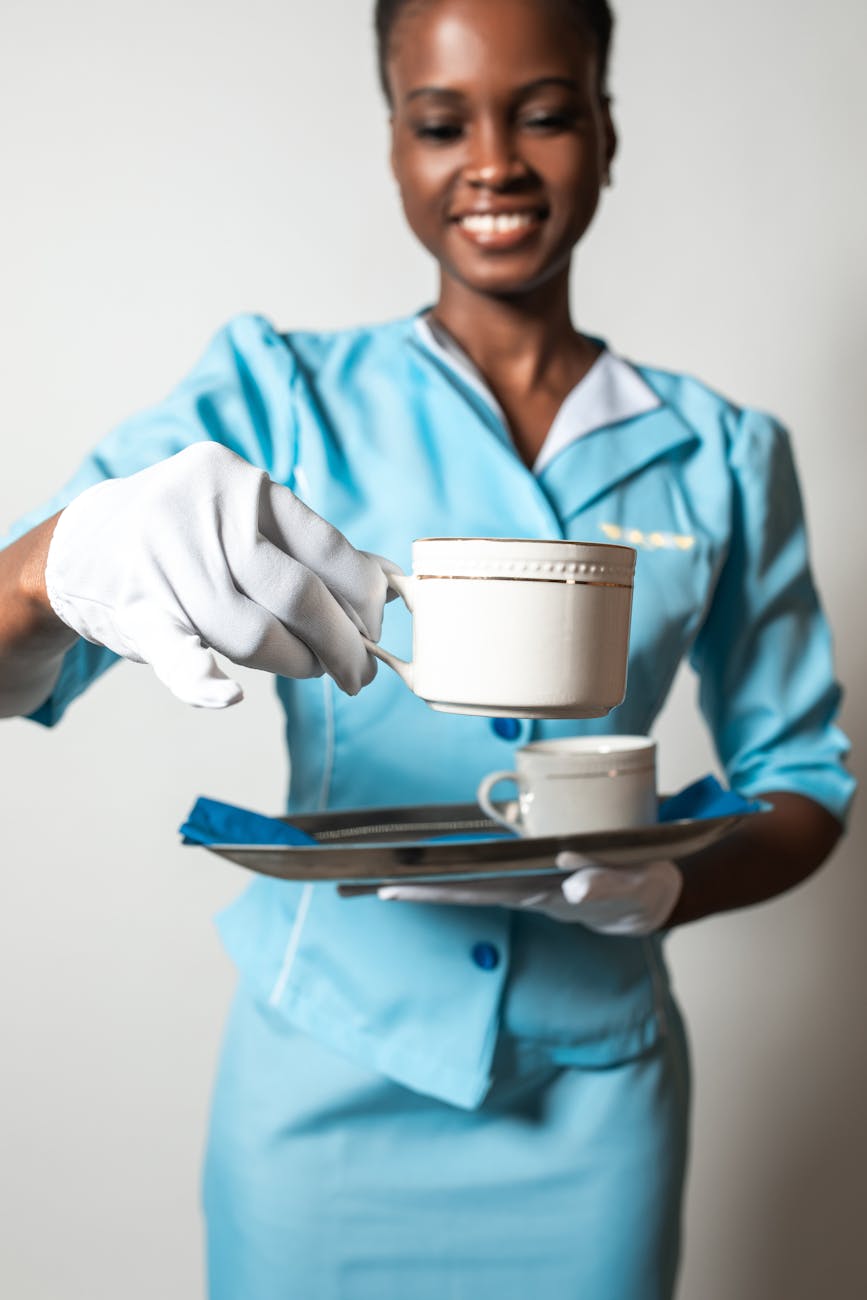 flight catering operations attendant smiling while holding a cup of coffee and a tray